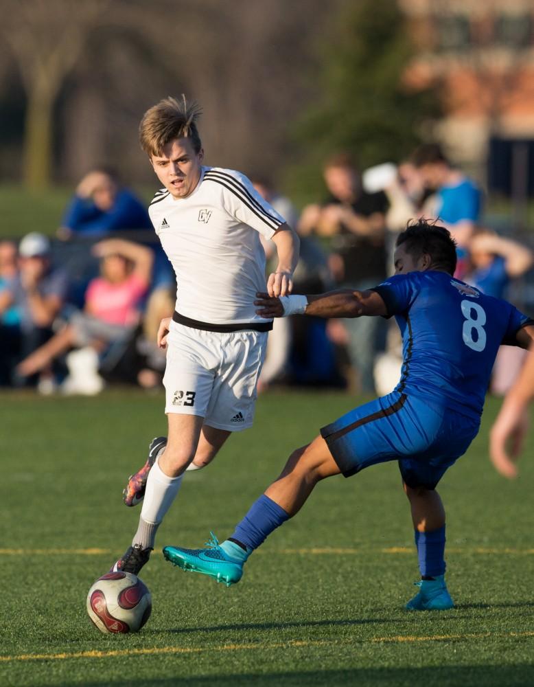 GVL / Kevin Sielaff - Chase Nielson (23) carries the ball upfield. Grand Valley's men's club soccer team falls to GRFC with a final score of 2-0 on Friday, April 15, 2016.