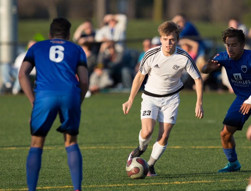 GVL / Kevin Sielaff - Chase Nielson (23) carries the ball upfield. Grand Valley's men's club soccer team falls to GRFC with a final score of 2-0 on Friday, April 15, 2016.