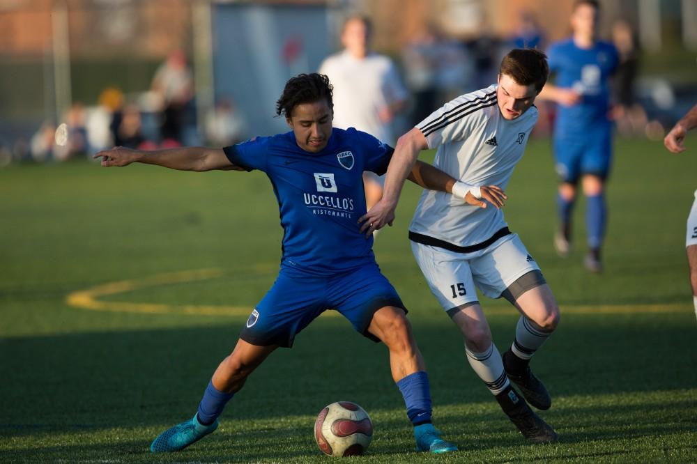 GVL / Kevin Sielaff -  Russell Reichenbach (15) fights for the ball at mid-field. Grand Valley's men's club soccer team falls to GRFC with a final score of 2-0 on Friday, April 15, 2016.