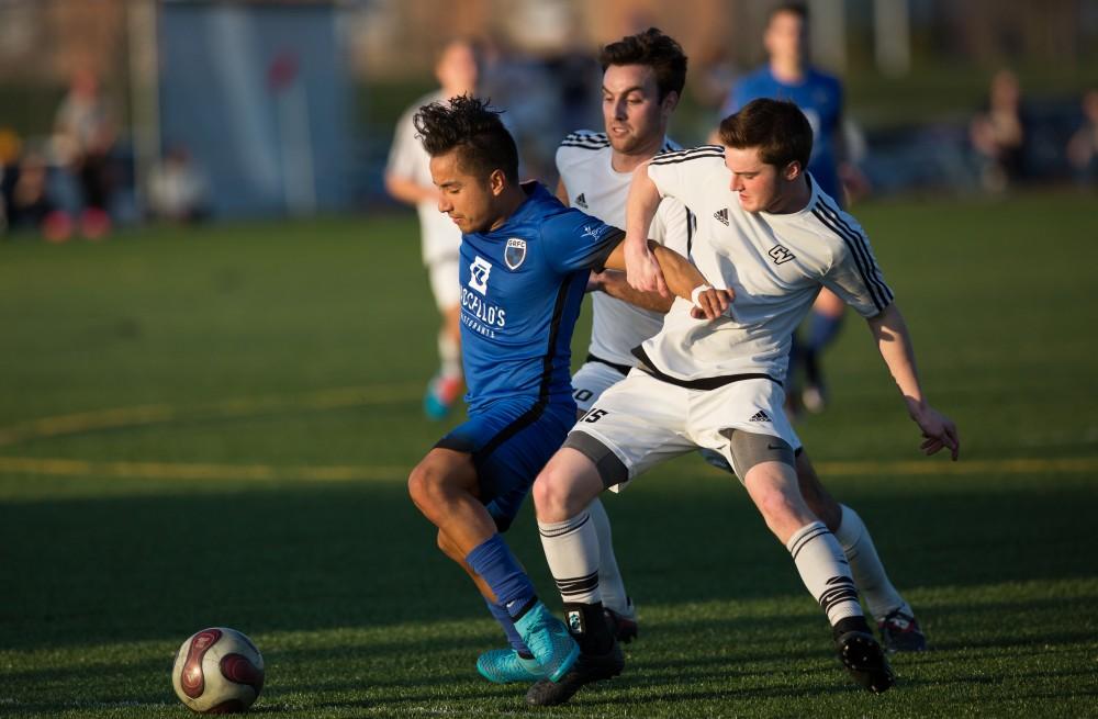 GVL / Kevin Sielaff -  Russell Reichenbach (15) fights for the ball at mid-field. Grand Valley's men's club soccer team falls to GRFC with a final score of 2-0 on Friday, April 15, 2016.