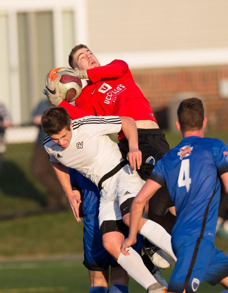 GVL / Kevin Sielaff - Griffon Dean (20) makes contact with the GRFC goalkeeper while attempting to head the ball into the net. Grand Valley's men's club soccer team falls to GRFC with a final score of 2-0 on Friday, April 15, 2016.