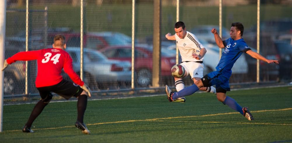 GVL / Kevin Sielaff - Robert Klein (13) tries a leaping shot on net. Grand Valley's men's club soccer team falls to GRFC with a final score of 2-0 on Friday, April 15, 2016.