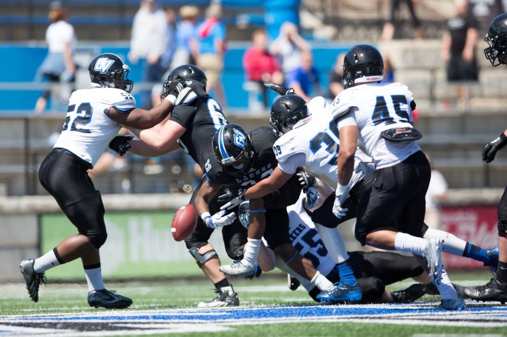 GVL / Kevin Sielaff - Christian Lumpkin (33) carries the ball upfield and is hit hard, causing a fumble. The 2016 Grand Valley State Spring Classic is hosted at Lubbers Stadium on Saturday, April 16, 2016.