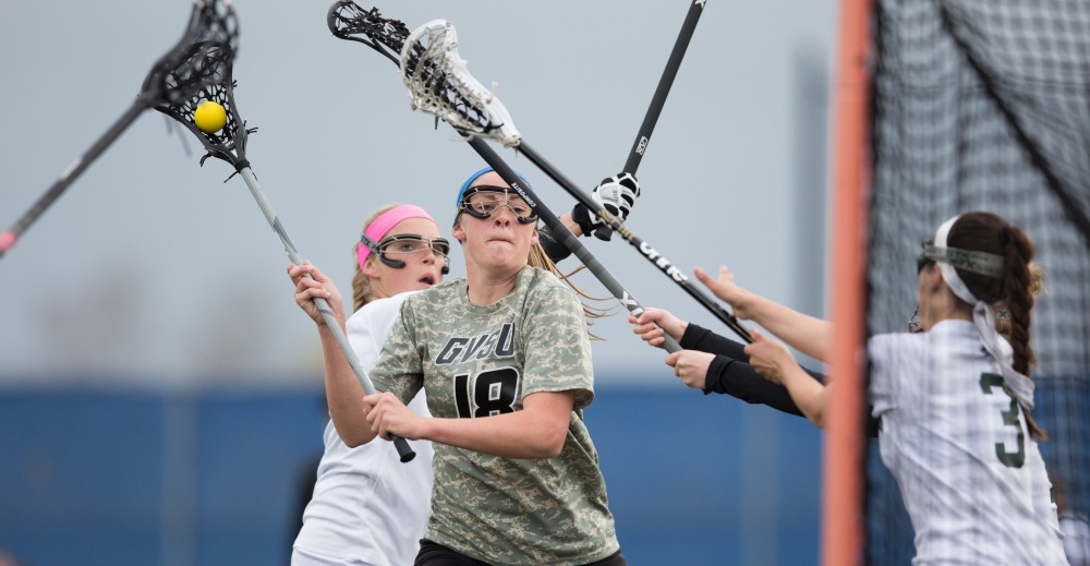 GVL / Kevin Sielaff - Meghan Datema (18) winds up, takes a shot on net, and scores. Grand Valley defeats Lake Erie College with a final score of 19-2 on Friday, April 29, 2016 in Allendale. 