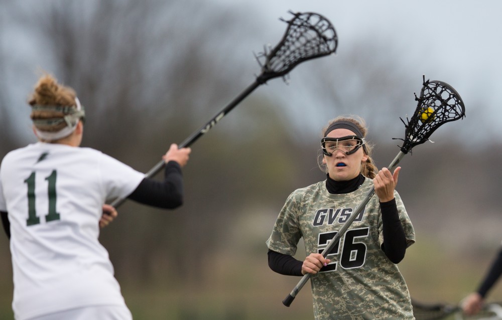 GVL / Kevin Sielaff - Katie Tomlinson (26) drives up the field and holds the ball. Grand Valley defeats Lake Erie College with a final score of 19-2 on Friday, April 29, 2016 in Allendale. 