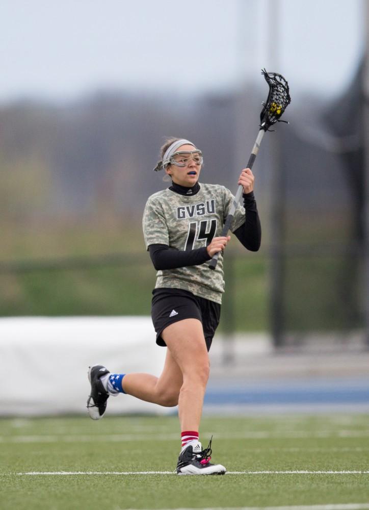 GVL / Kevin Sielaff - Chloe Zdybel (14) moves the ball up and out of Grand Valley's zone. Grand Valley defeats Lake Erie College with a final score of 19-2 on Friday, April 29, 2016 in Allendale. 