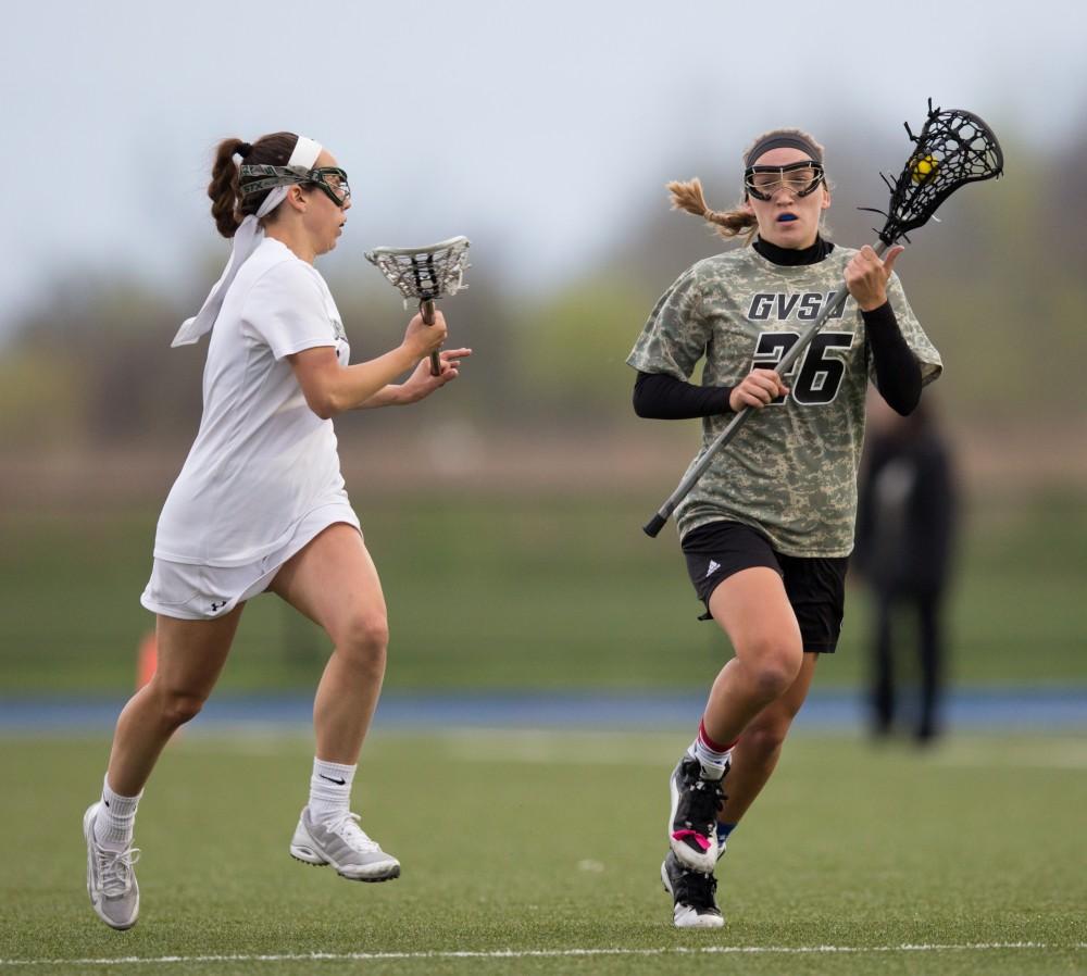 GVL / Kevin Sielaff - Katie Tomlinson (26) moves the ball up and past Laker Erie's defense. Grand Valley defeats Lake Erie College with a final score of 19-2 on Friday, April 29, 2016 in Allendale. 