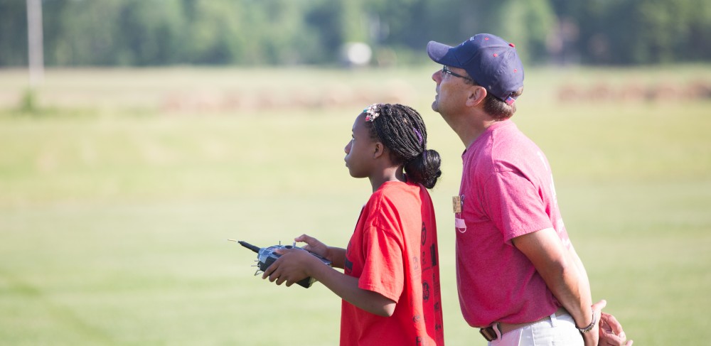 GVL / Kevin Sielaff - Koungo Diarrassouba flies the plane that she has built. Students of STEPS (Science, Technology, and Engineering Day Camps) fly planes that they have built during camp at Warped Wings Fly Field in Allendale on Thursday, June 23, 2016. 