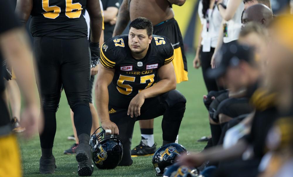 GVL/Kevin Sielaff - Brandon Revenberg (57) rests on the sideline in between plays. The Hamilton Tiger-Cats square off against the Saskatchewan Roughriders Saturday, August 20, 2016 in Hamilton, Ontario.