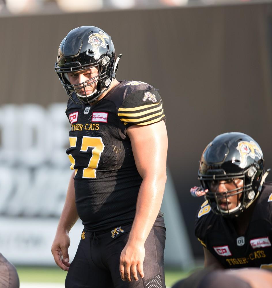 GVL/Kevin Sielaff - Brandon Revenberg (57) runs drills before the start of the match. The Hamilton Tiger-Cats square off against the Saskatchewan Roughriders Saturday, August 20, 2016 in Hamilton, Ontario. 