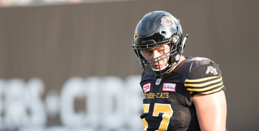 GVL/Kevin Sielaff - Brandon Revenberg (57) runs drills before the start of the match. The Hamilton Tiger-Cats square off against the Saskatchewan Roughriders Saturday, August 20, 2016 in Hamilton, Ontario. 