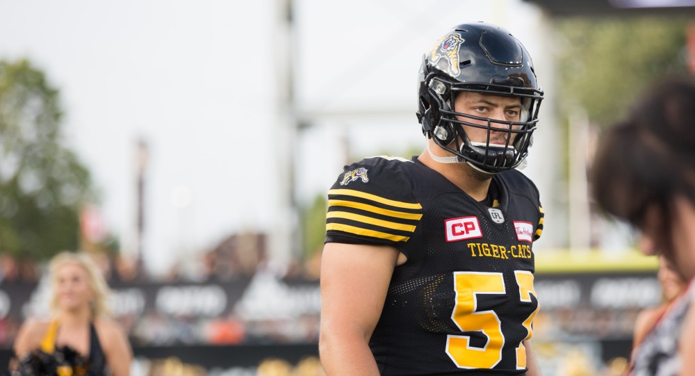 GVL/Kevin Sielaff - Brandon Revenberg (57) and the Tiger-Cats take the field. The Hamilton Tiger-Cats square off against the Saskatchewan Roughriders Saturday, August 20, 2016 in Hamilton, Ontario. GVL/Kevin Sielaff - The Hamilton Tiger-Cats square off against the Saskatchewan Roughriders Saturday, August 20, 2016 in Hamilton, Ontario. 