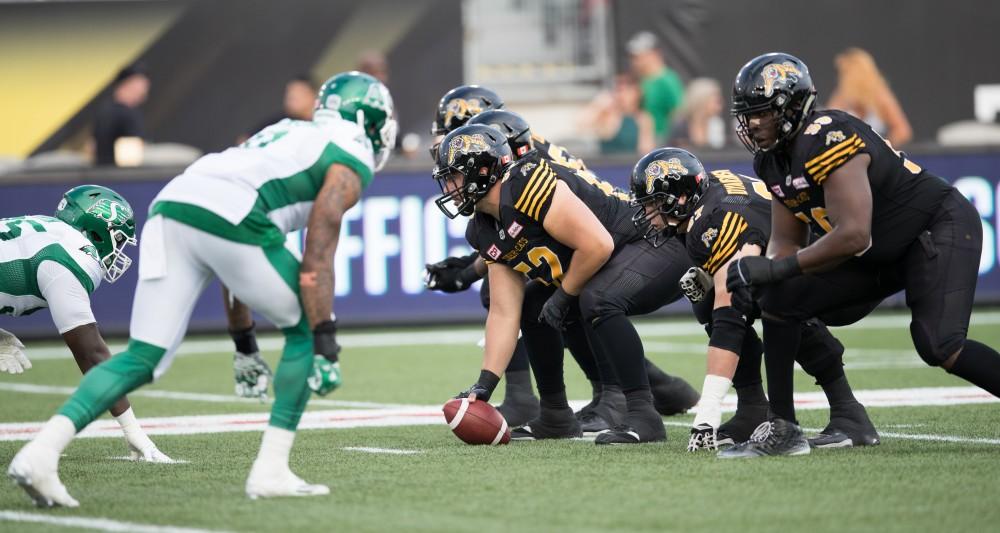 GVL/Kevin Sielaff - Mathieu Girard (52) sets up on the line and scrimmage and prepares to hike the football. The Hamilton Tiger-Cats square off against the Saskatchewan Roughriders Saturday, August 20, 2016 in Hamilton, Ontario. 