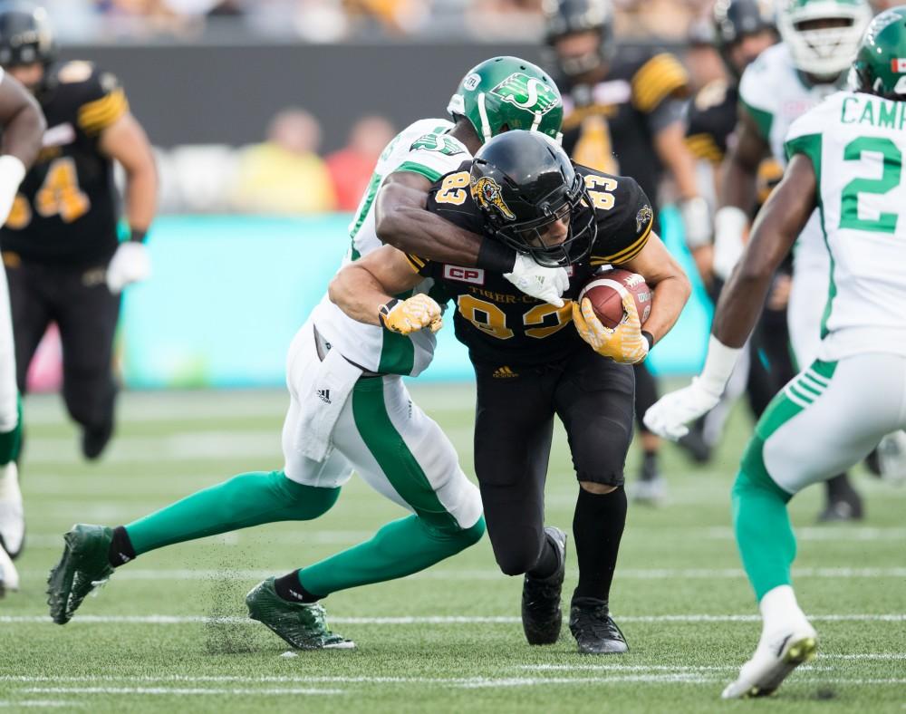 GVL/Kevin Sielaff - Andy Fantuz (83) receives a pass and tries to gain yardage before being tackled to the turf. The Hamilton Tiger-Cats square off against the Saskatchewan Roughriders Saturday, August 20, 2016 in Hamilton, Ontario. 