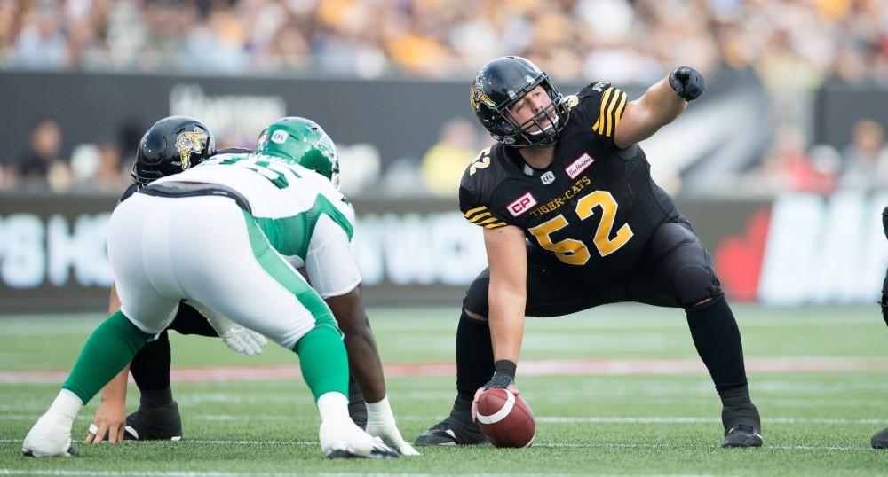 GVL/Kevin Sielaff - Mathieu Girard (52) organizes his offensive line before hiking the football. The Hamilton Tiger-Cats square off against the Saskatchewan Roughriders Saturday, August 20, 2016 in Hamilton, Ontario. 