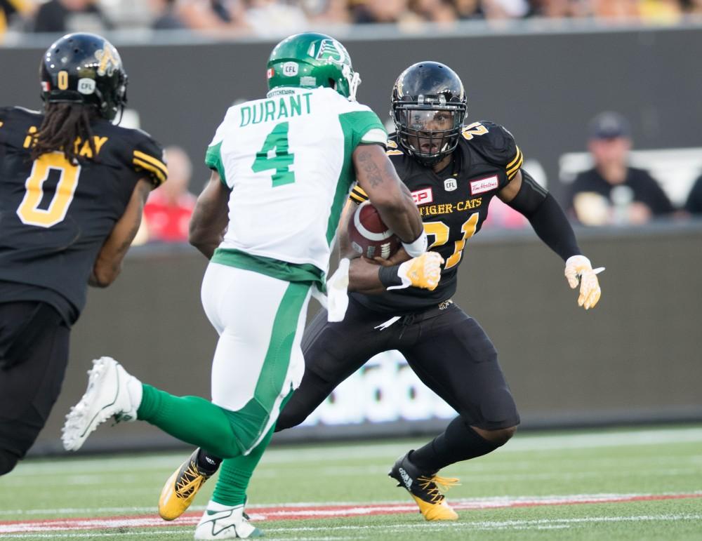 GVL/Kevin Sielaff - Simoni Lawrence (21) jukes in front of opposing QB Darian Durant (4) to make the tackle. The Hamilton Tiger-Cats square off against the Saskatchewan Roughriders Saturday, August 20, 2016 in Hamilton, Ontario.