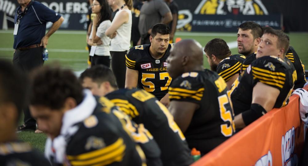 GVL/Kevin Sielaff - Brandon Revenberg (57) rests on the sideline in between plays. The Hamilton Tiger-Cats square off against the Saskatchewan Roughriders Saturday, August 20, 2016 in Hamilton, Ontario. 