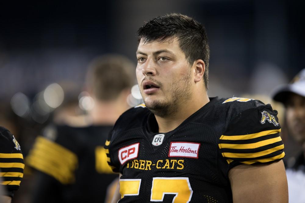 GVL/Kevin Sielaff - Brandon Revenberg (57) rests on the sideline in between plays. The Hamilton Tiger-Cats square off against the Saskatchewan Roughriders Saturday, August 20, 2016 in Hamilton, Ontario.