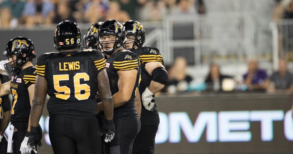 GVL/Kevin Sielaff - Brandon Revenberg (57) huddles with his team before taking to the line of scrimmage. The Hamilton Tiger-Cats square off against the Saskatchewan Roughriders Saturday, August 20, 2016 in Hamilton, Ontario. 