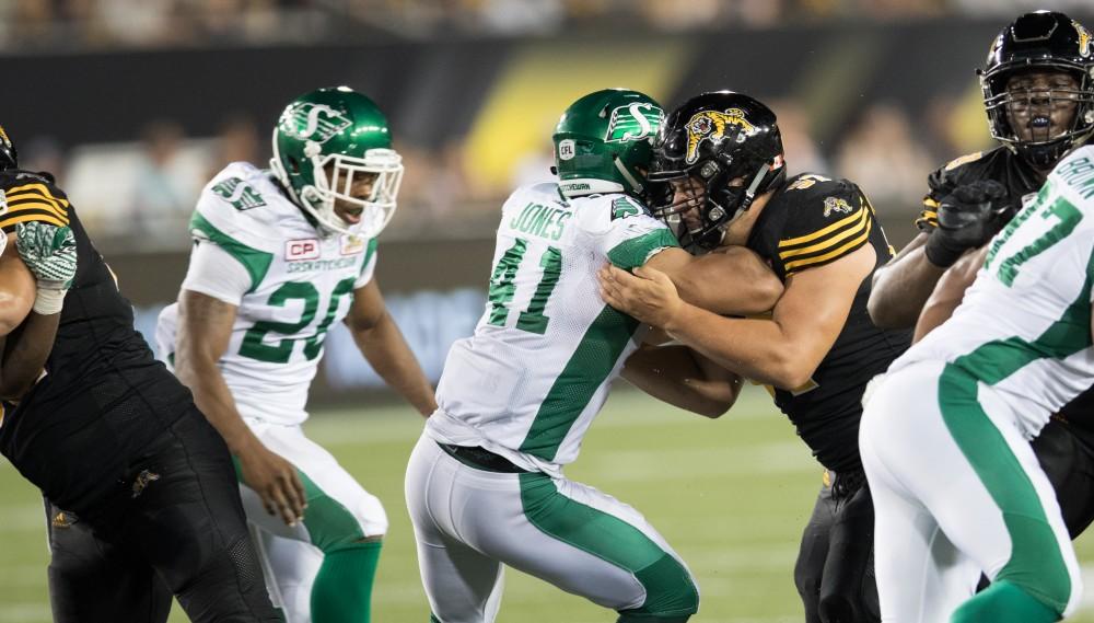 GVL/Kevin Sielaff - Brandon Revenberg (57) holds the offensive line. The Hamilton Tiger-Cats square off against the Saskatchewan Roughriders Saturday, August 20, 2016 in Hamilton, Ontario. 