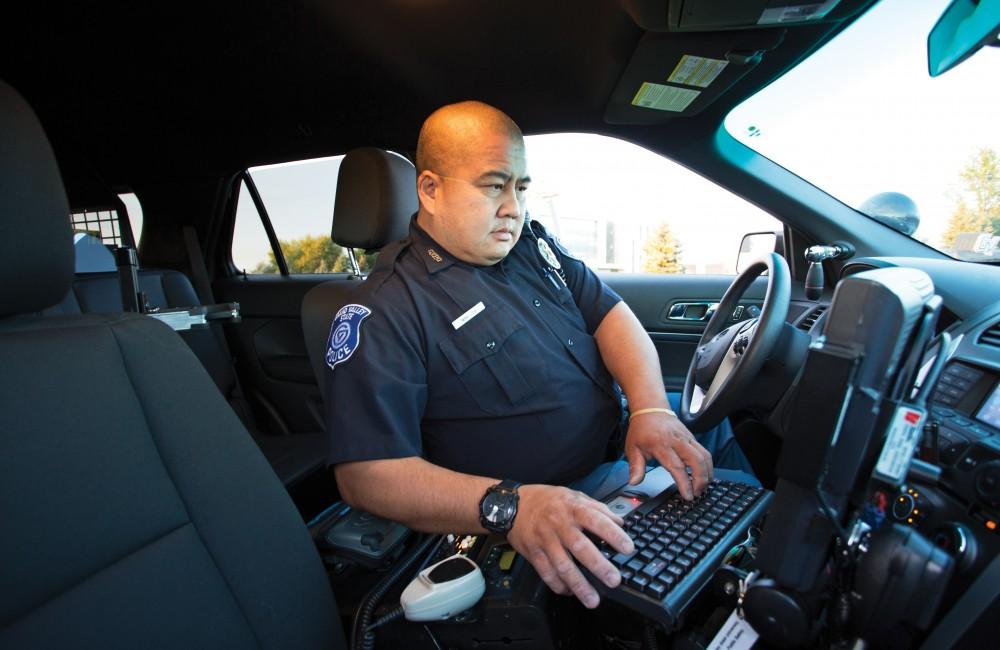 GVL/Kevin SielaffGVPD officer Minh Lien works within his patrol car Sept. 13 outside of Campus Life Night. 