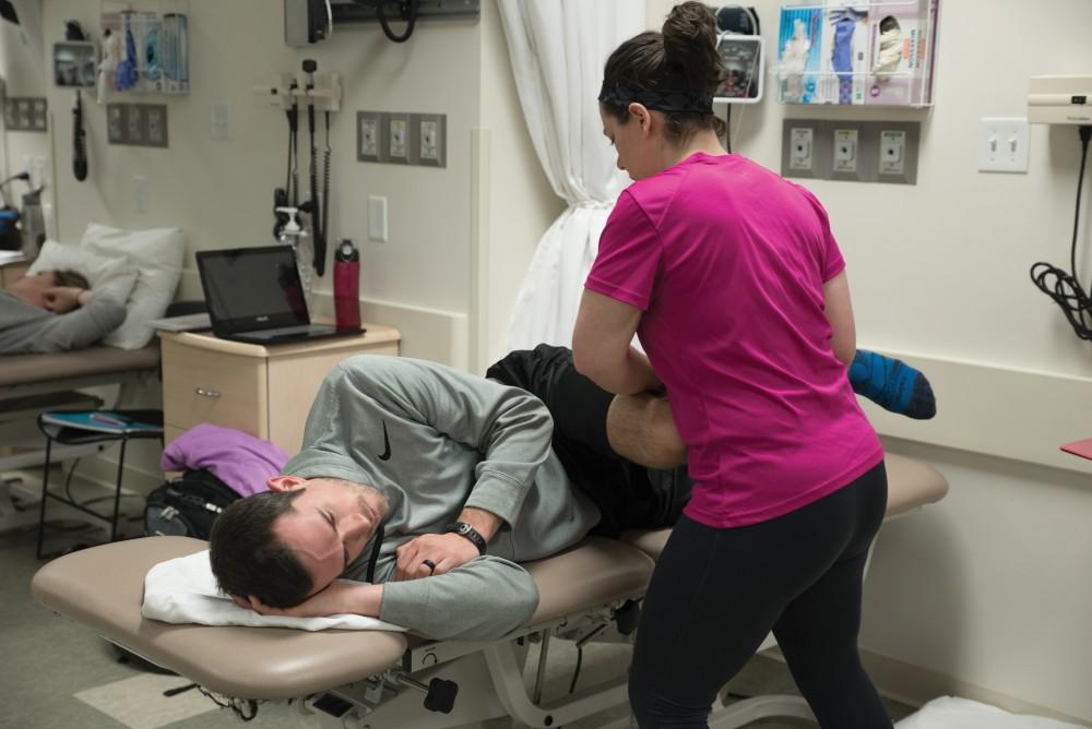 GVL/Luke HolmesMelissa Perla helps strectch out Grant Fall in the Physical Therapy room in the Center for Health Sciences Wednesday, Feb. 10, 2016.