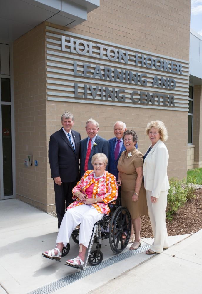 GVL/Kevin Sielaff - President Thomas Haas and his wife Marcia Haas stand with the Holton and Hooker families in front of the Holton-Hooker Learning and Living Center on Friday, August 26, 2016.   