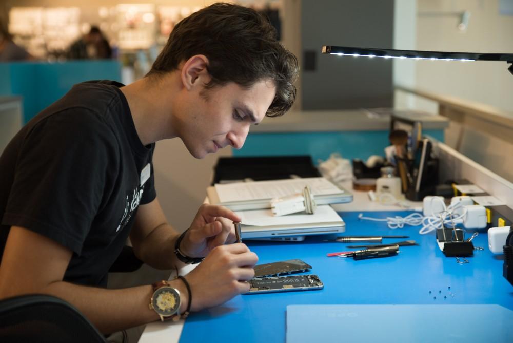 GVL / Luke Holmes - Dylan Kernohan works on a broken iPhone at the Genius Phone Repair shop in the GVSU Marketplace.