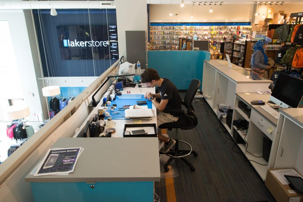 GVL / Luke Holmes - Dylan Kernohan works on a broken iPhone at the Genius Phone Repair shop in the GVSU Marketplace.