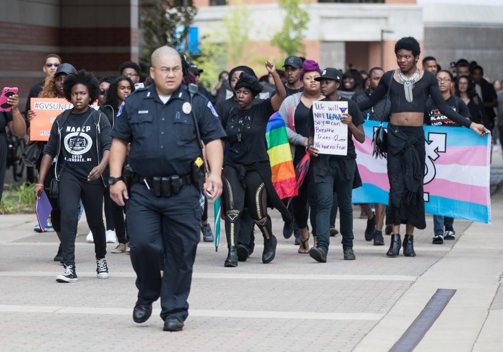GVL/Kevin Sielaff - Officer Minh Lien secures the area as protestors move through. Grand Valleys NAACP chapter holds a campus wide demonstration in protest of police brutality Friday, Sept. 23, 2016 in Allendale.