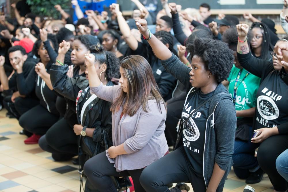 GVL/Kevin Sielaff - Cheyanna Green-Molett raises her first alongside a crowd of students participating in the silent march inside the Kirkhof Center. Grand Valley's NAACP chapter holds a campus wide demonstration in protest of police brutality Friday, Sept. 23, 2016 in Allendale.