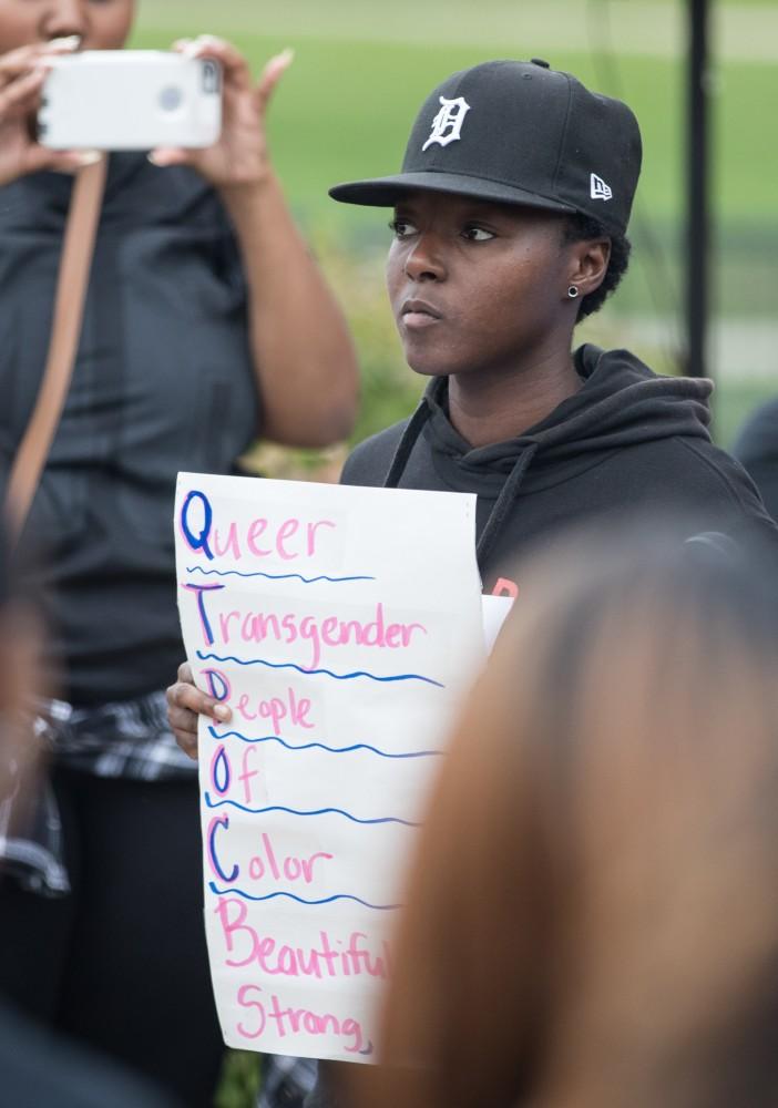 GVL/Kevin Sielaff - Ezra Smith holds a sign in support of queer and transgender rights during a campus wide demonstration in protest of police brutality Friday, Sept. 23, 2016 in Allendale.