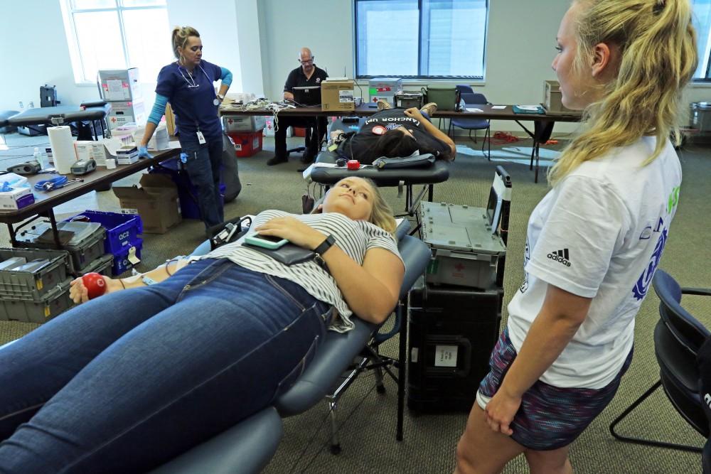 GVL / Emily Frye  
Alaina White donates blood while her friend Abby Near waits by her side on Tuesday Sept. 20, 2016.