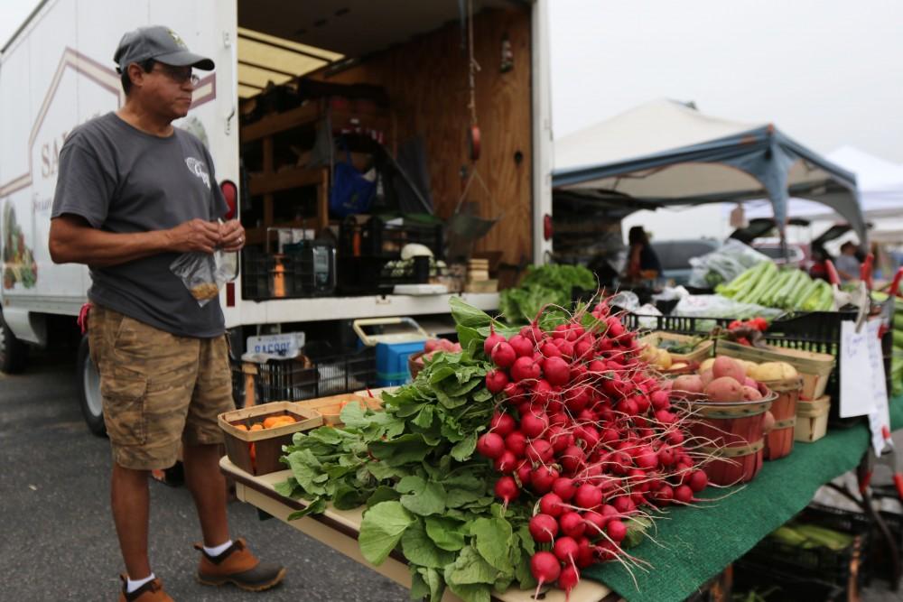 GVL / Luke Holmes - Marty Rodriguez sells fresh produce at the Farmers Market in Parking Lot G on Wednesday, Sept. 7, 2016.