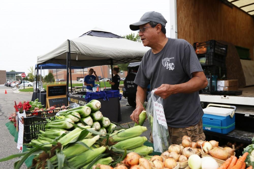 GVL / Luke Holmes - Marty Rodriguez sells fresh produce at the Farmers Market in Parking Lot G on Wednesday, Sept. 7, 2016.