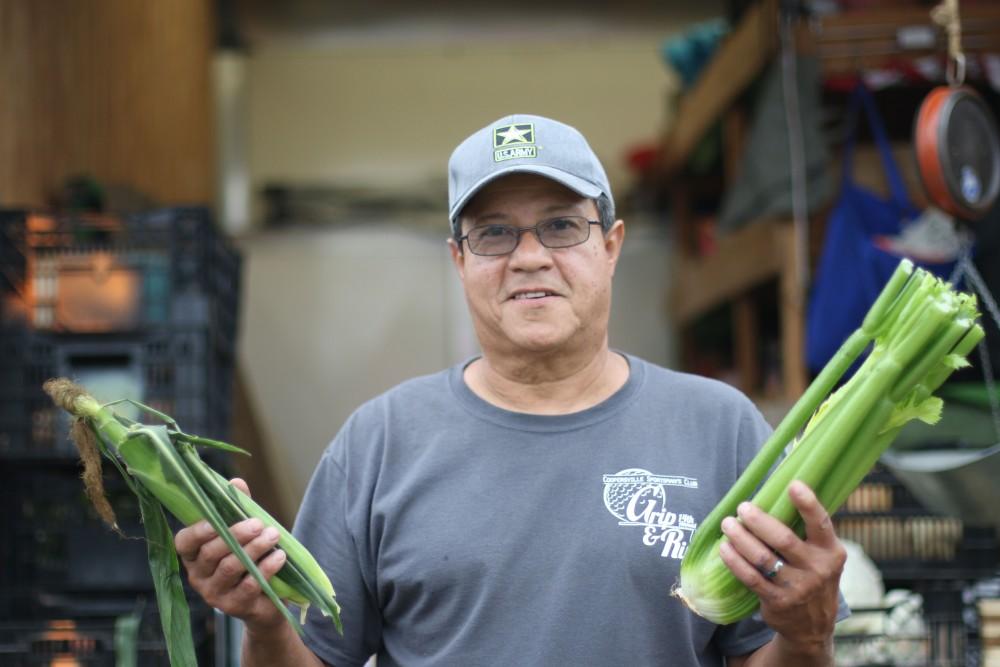 GVL / Luke Holmes - Marty Rodriguez sells fresh produce at the Farmers Market in Parking Lot G on Wednesday, Sept. 7, 2016.