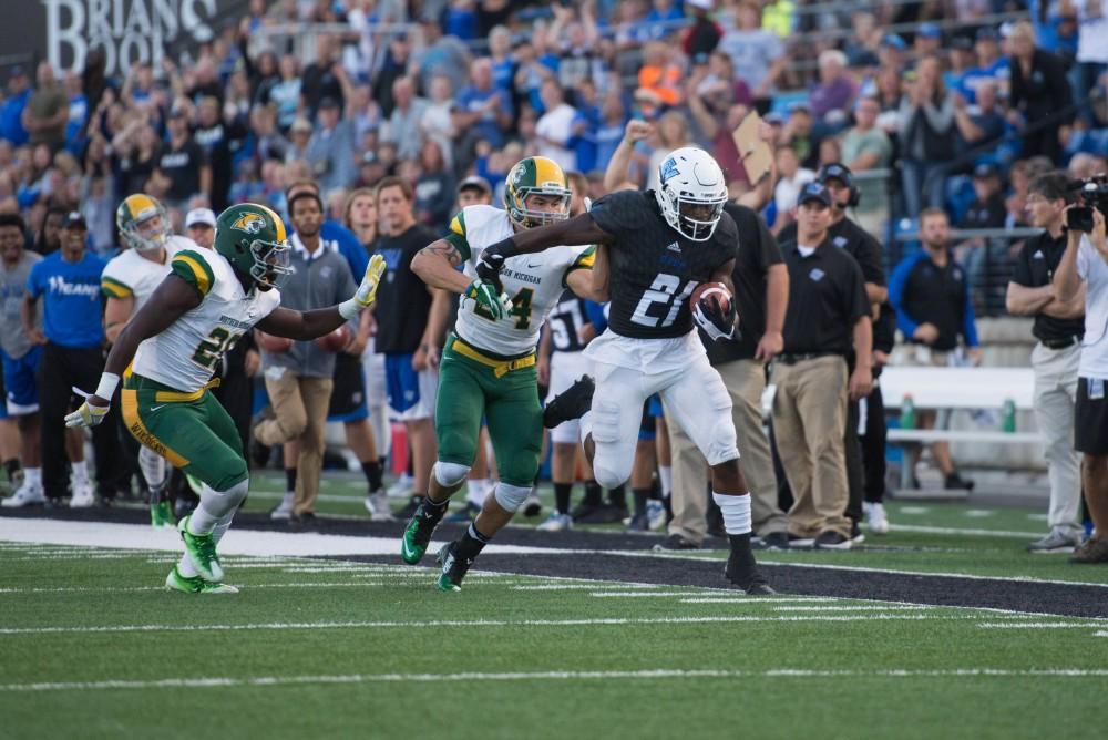 GVL / Luke Holmes - The team comes through the tunnel at the beginning of the game. GVSU defeated Northern Michigan University 50-24 in Lubber's Stadium on Saturday, Sept. 17, 2016.