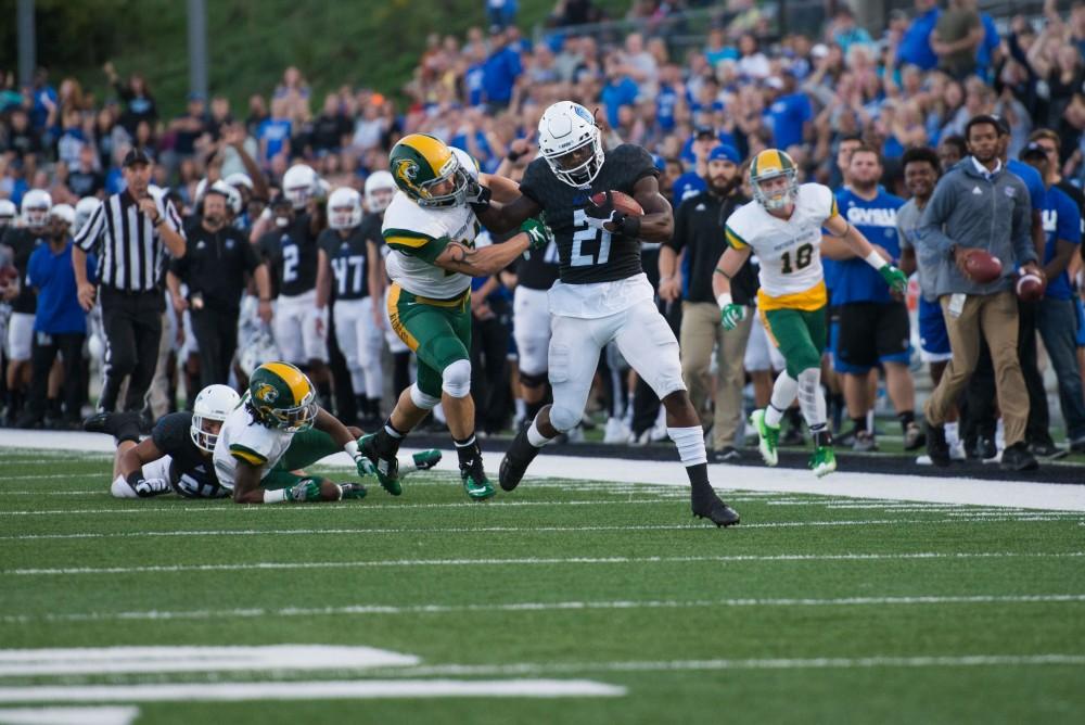 GVL / Luke Holmes - Marty Carter (21) runs and blocks his defenders. GVSU defeated Northern Michigan University 50-24 in Lubber's Stadium on Saturday, Sept. 17, 2016.