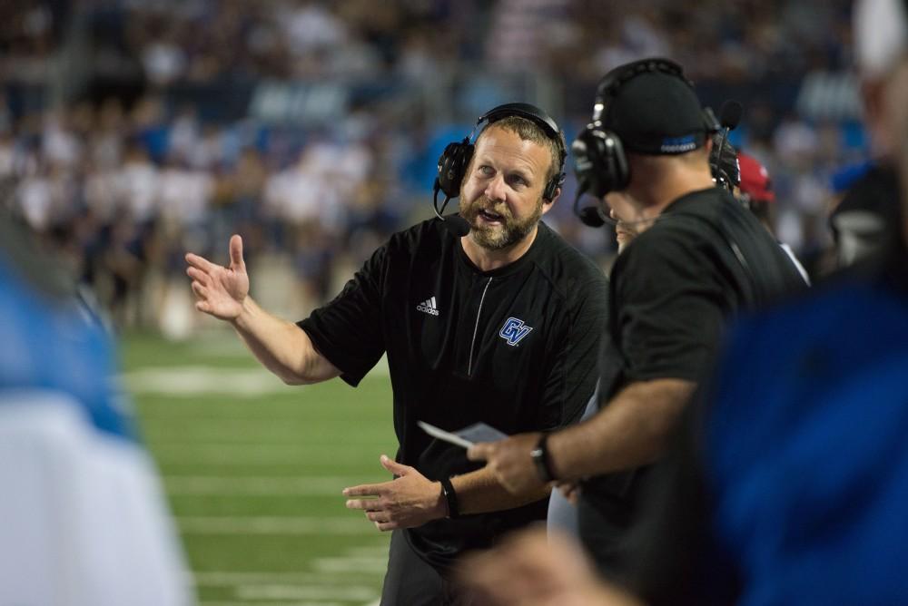 GVL / Luke Holmes - Matt Mitchell communicates with the other coaches. GVSU defeated Northern Michigan University 50-24 in Lubber's Stadium on Saturday, Sept. 17, 2016.