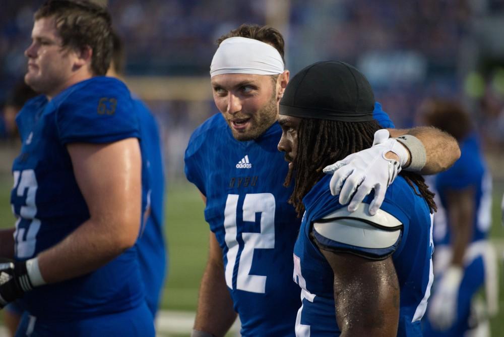 GVL / Luke Holmes - Ryan West (12) puts his arm around Terrell Dorsey (22) at half time. Grand Valley State University defeated Tiffin 45-7 on Thursday, Sep. 1, 2016.