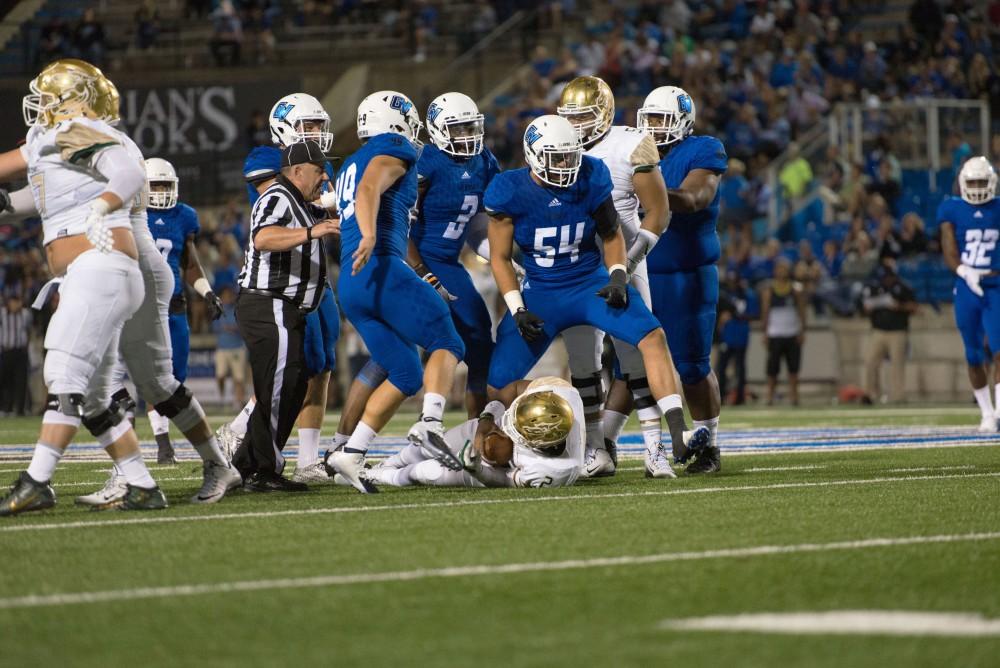 GVL / Luke Holmes - The defense huddles together after Dylan Carroll (54) makes the tackle. Grand Valley State University defeated Tiffin 45-7 on Thursday, Sep. 1, 2016.