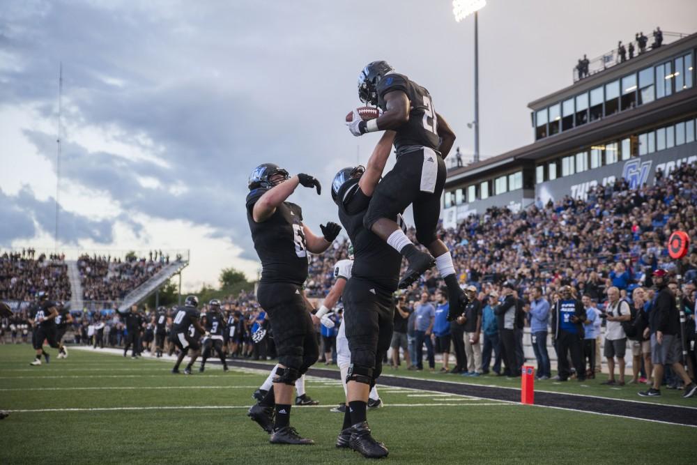 GVL / Luke Holmes - The team celebrates after Marty Carter (21) scores a touchdown.