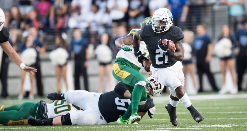 GVL/Kevin Sielaff - Marty Carter (21) breaks a tackle and sprints toward the end zone. The Lakers defeat the Wildcats of Northern Michigan with a final score of 50-24 on Saturday, Sept. 17, 2016 in Allendale.