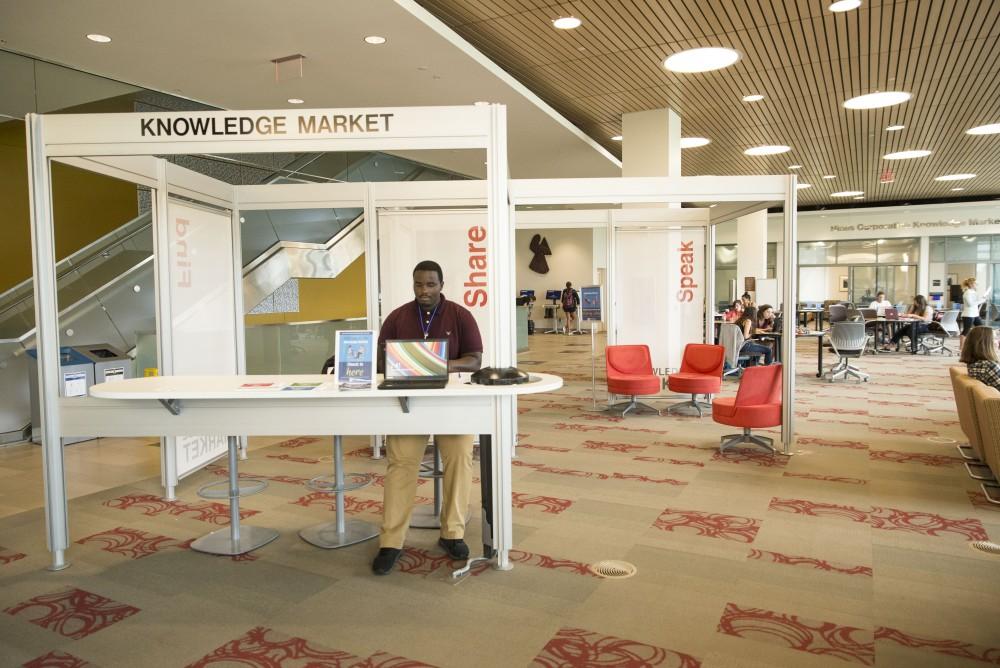 GVL / Luke Holmes - Isaac Clark works the front desk at the Knowledge Market in the Mary Idema Pew Library.