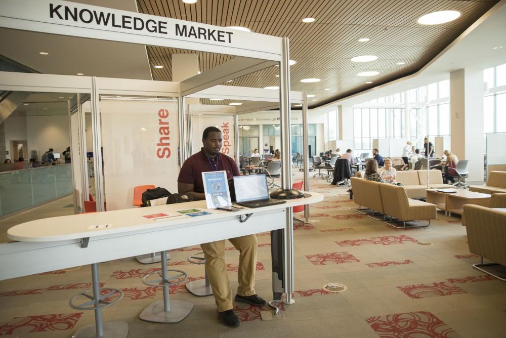 GVL / Luke Holmes - Isaac Clark works the front desk at the Knowledge Market in the Mary Idema Pew Library.