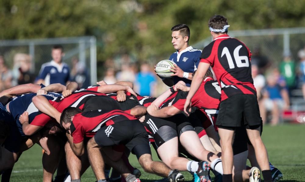 GVL/Kevin Sielaff - Marcus Tolic (9) sets the ball into the scrum. GVSU men's club rugby defeats rival SVSU by a large margin Saturday, Sept. 24, 2016. 