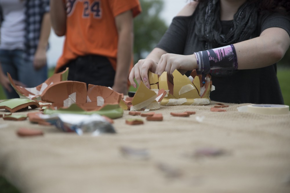 GVL / Luke Holmes - A student puts back together a broken pot. The Paleo-Olympics were held in the KC West Lawn on Friday, Sept. 23, 2016.