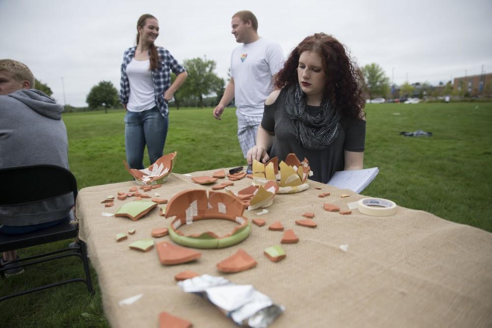 GVL / Luke Holmes - Madison Rogers puts back together a broken pot. The Paleo-Olympics were held in the KC West Lawn on Friday, Sept. 23, 2016.