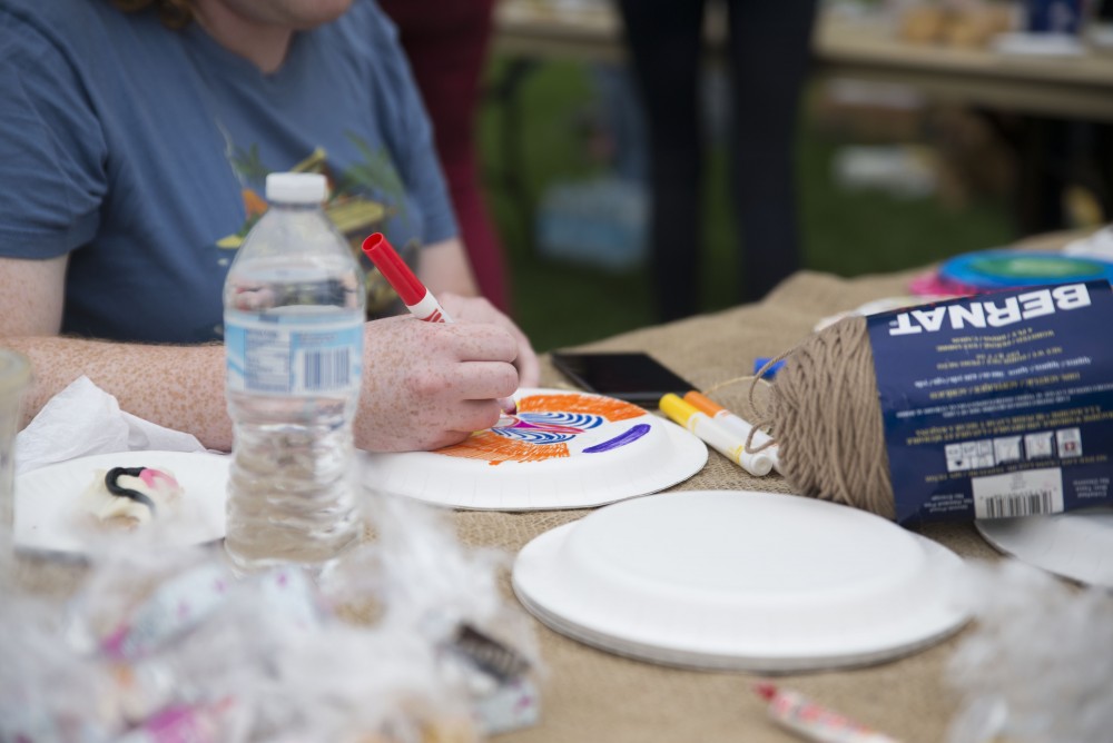 GVL / Luke Holmes - A student decorates a plate to be a Roman shield. The Paleo-Olympics were held in the KC West Lawn on Friday, Sept. 23, 2016.