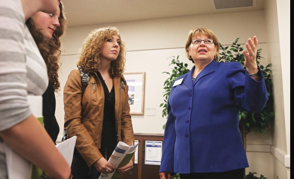 GVL/Kevin Sielaff - Lori Houghton (right) speaks with students Tuesday, Oct. 7, 2014 during the research fair held in the Grand River Room.